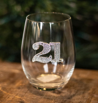 Stemless wine glass says, "21" in silvery numbers encrusted with clear rhinestones
