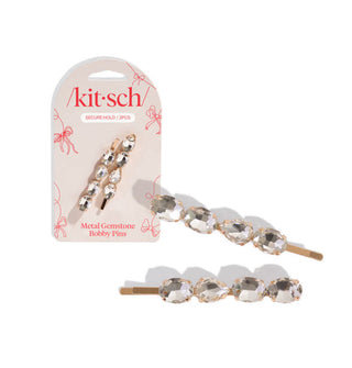 Two rose gold bobby pins affixed with four clear faceted gemstones each are shown on a pink Kitsch product card and againm enlarged, at right