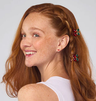 Smiling model wears two cherry rhinestone clips in a side braid