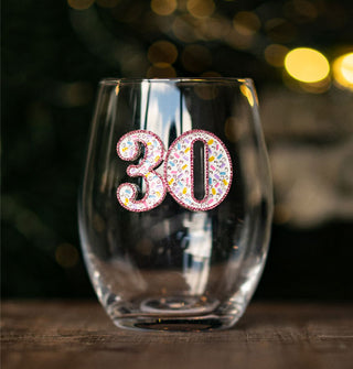 Clear stemless wine glass features a "30" decal embellished with multicolored rhinestones