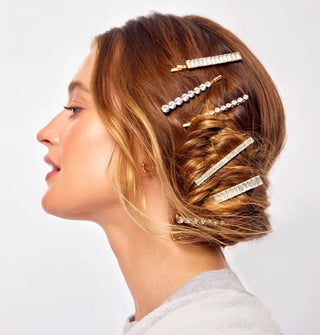 Model wears rhinestone-encrusted bobby pins in a side-swept messy bun
