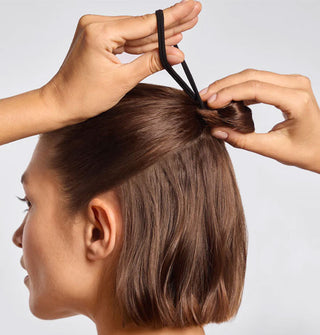 Model fits a half-up bun with a black fabric hair elastic