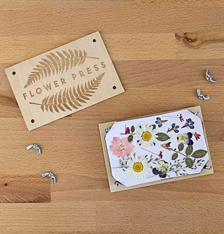 Components of the DIY Flower Press Kit spread out on a wooden tabletop