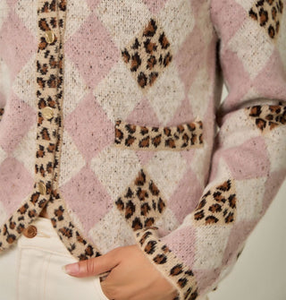 Model wears a pink and white diamond print cardigan with contrasting leopard print diamond accents, button placket, bottom hem, sleeve cuffs, and pocket edges