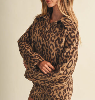 Model with arms crossed wears a leopard print jacket with an oversized fit and matching cloth-covered buttons, paired with matching skirt