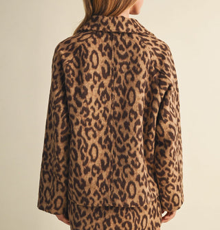Back view of a collared leopard print jacket and matching mini skirt as worn by a model