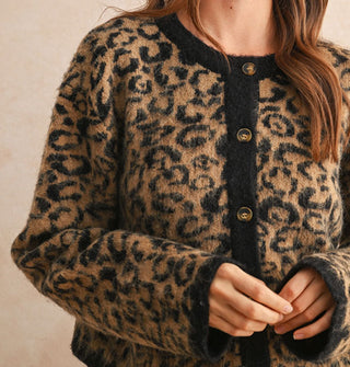 Model wears a leopard print button-down cardigan with black placket, neckline, and sleeve cuffs
