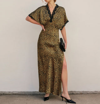 Model wears a full-length satin leopard print dress with black lace trim and thigh-high side slit