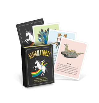Black box of Affirmators! cards featuring illustration of a bunny riding a unicorn in front of a rainbow is placed in front of a fan of four sample cards from the deck