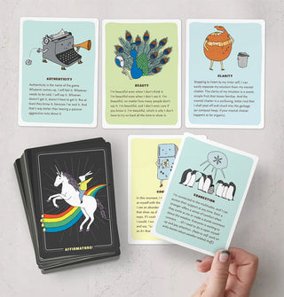 Model's hand holds a card from a spread of Affirmators! affirmation cards