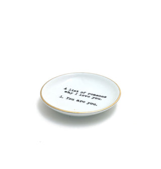 Round white dish with gold rim says in black stamped lettering, "A list of reasons why I love you. 1. You are you." 