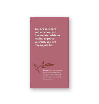 Rectangular dusty rose-colored card says, "You are safe here and now. You are free to exist without having to prove yourself. You are free to just be."