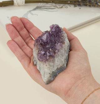 Model's hand holds a large chunk of amethyst