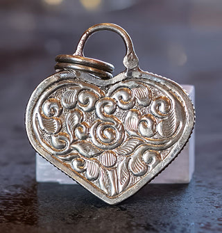Pendant back features intricate leaf and swirl engraved design