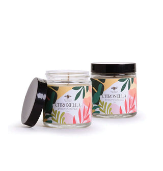 Two Citronella candles in glass jars, one with black screw-on lid removed, and one with lid on