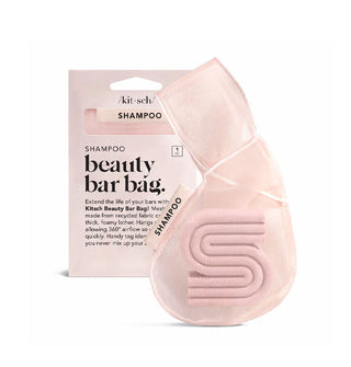 Light pink meshy Kitsch Shampoo Beauty Bar Bag is shown holding a ribbed S-shaped shampoo bar alongside its box packaging