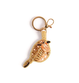 A beaded bird charm hangs from gold split ring and lobster clasp keychain hardware
