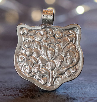 Silver pendant back in the shape of an animal's head with ornate floral engraving and a top-set rounded bail with circular accents