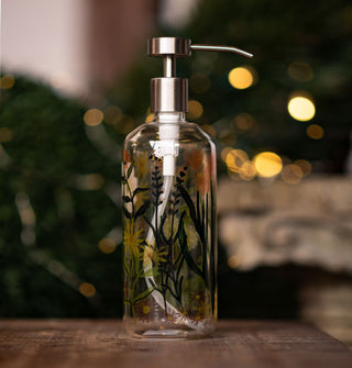 Glass soap dispenser with stainless steel pump top features a painted design of wildflowers and bumblebees