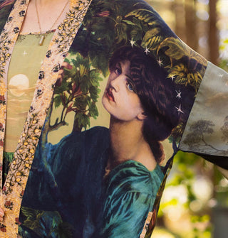 Closeup of a classical woman's portrait accented by white stars on one panel of a loose-fitting robe with floral trim