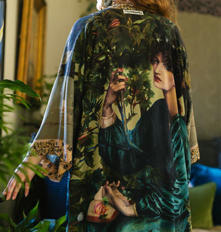 A classical woman's portrait is printed on the back of a loose-fitting robe worn by a model