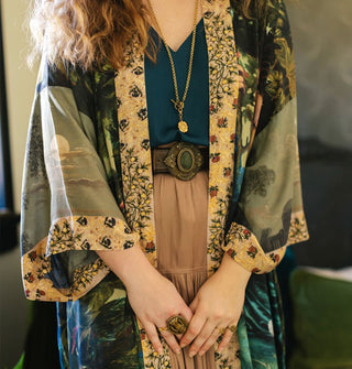 Model wears a loose-fitting printed robe with floral trim