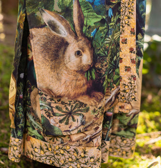 Closeup of a rabbit illustration at the bottom of a loose-fitting robe with floral trim