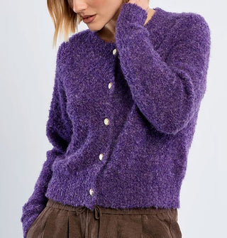 Model wears a purple cardigan with white buttons