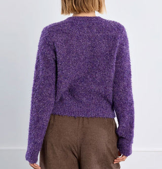 Model facing away from the camera wears a purple bouclé knit sweater
