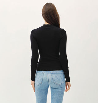 Model facing away from the camera wears a long-sleeved black mock turtleneck top with blue jeans