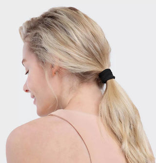 Model wears a black recycled nylon hair elastic in a low ponytail