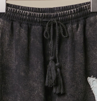 Elastic tie waist on a pair of black  washed cotton pants held by hanger clamps