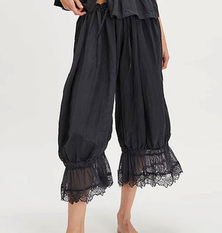Model wears a pair of black lace-trimmed bloomers