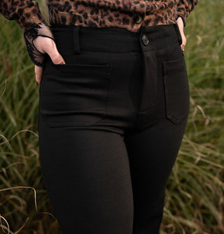 Model wears black pants with a long-sleeved leopard print cardigan and fingerless black lace gloves