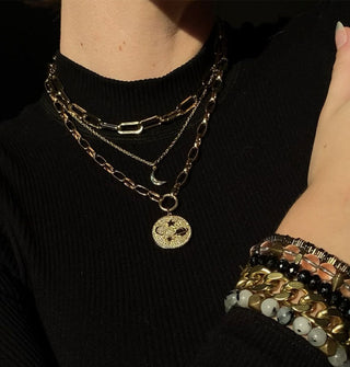 Model wears an assortment of gold necklaces and bracelets