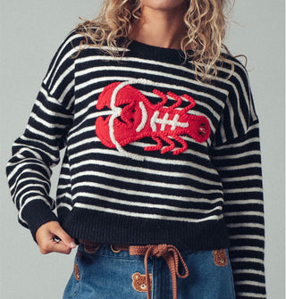 Model wears a black and white striped long-sleeved sweater with a large red and white embroidered lobster design on the front