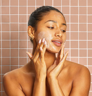 Model lathers cheeks against a tiled backdrop