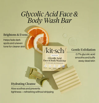 A bar of Kitsch Resurfacing Glycolic Acid Face & Body Wash Bar, its box, and pieces of aloe and citrus are labeled with the product's key benefits (Brightens & Evens, Hydrating Cleanse, Gentle Exfoliation)