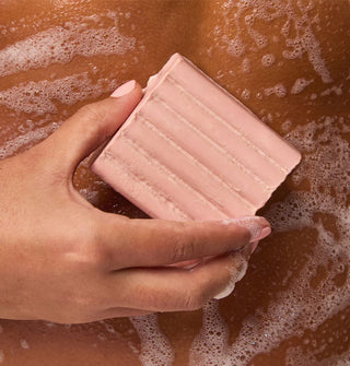 Model lathers a bar of soap onto skin