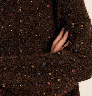 Closeup of dark brown bouclé knot with multicolored flecks and silver sequins sewn in