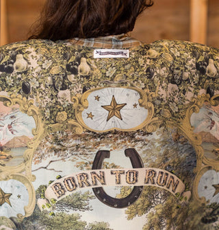 Detail of the "Born to run" banner and horseshoe beneath framed stars on an intricately patterned garment