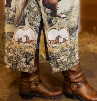 Model in boots wears a kimono-style robe with floral and equestrian design themes
