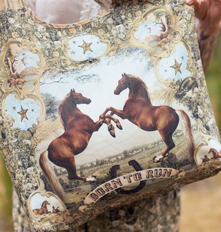 Tote bag with mixed prints features an image of two rearing horses above a banner that reads, "Born to run"