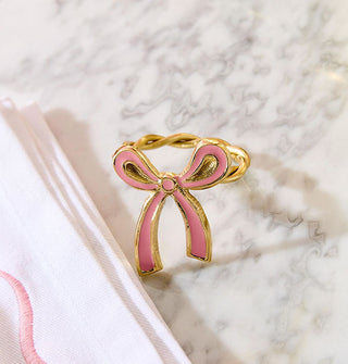 Gold napkin ring with pink enamel bow accent