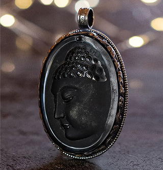 Oval-shaped black onyx Buddha face cameo pendant in silver setting with rounded top-set bail