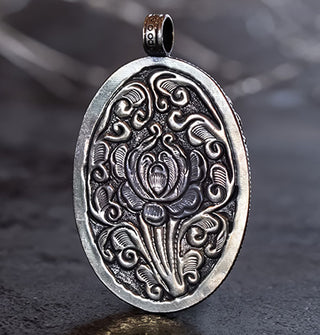 Oval-shaped engraved silver pendant back with floral motif
