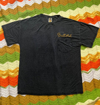 Black T-shirt on a multicolored zigzag print blanket features the word, "Bullshit" in yellow above its breast pocket