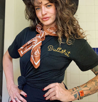 Model with hands on hips wears a "Bullshit" embroidered black T-shirt