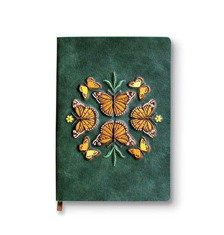 Green journal cover features symmetrical design of eight monarch butterflies with leaf and flower accents