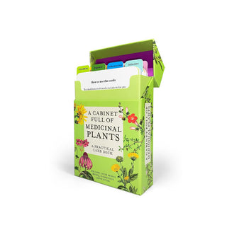 A Cabinet Full of Medicinal Plants card deck box with the top lid flipped open to reveal color-coded tabbed sections of cards inside